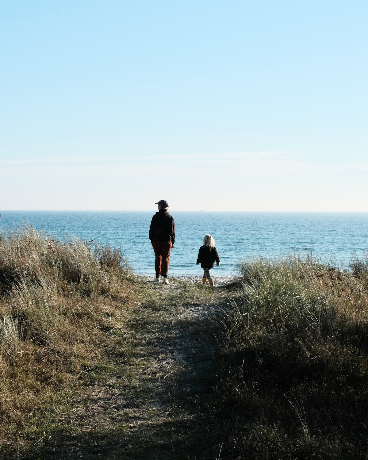 Erwachsener und Kind an den Duenen