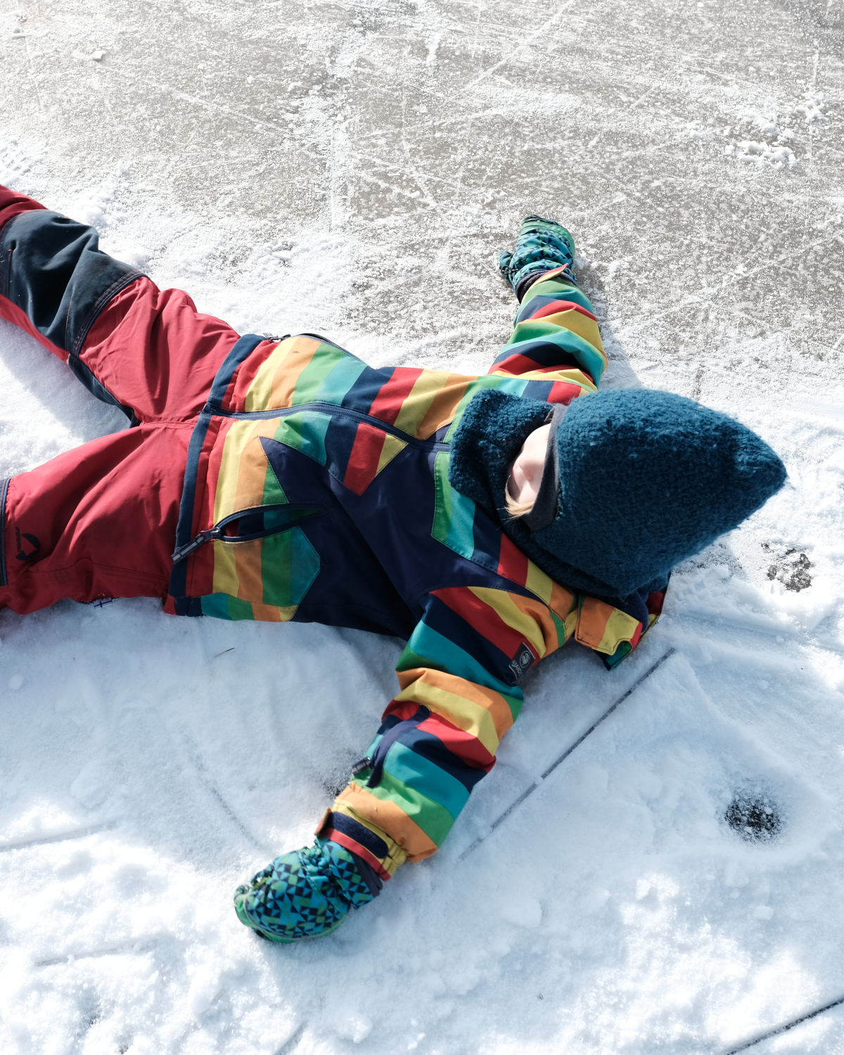 Kind liegt im Schnee