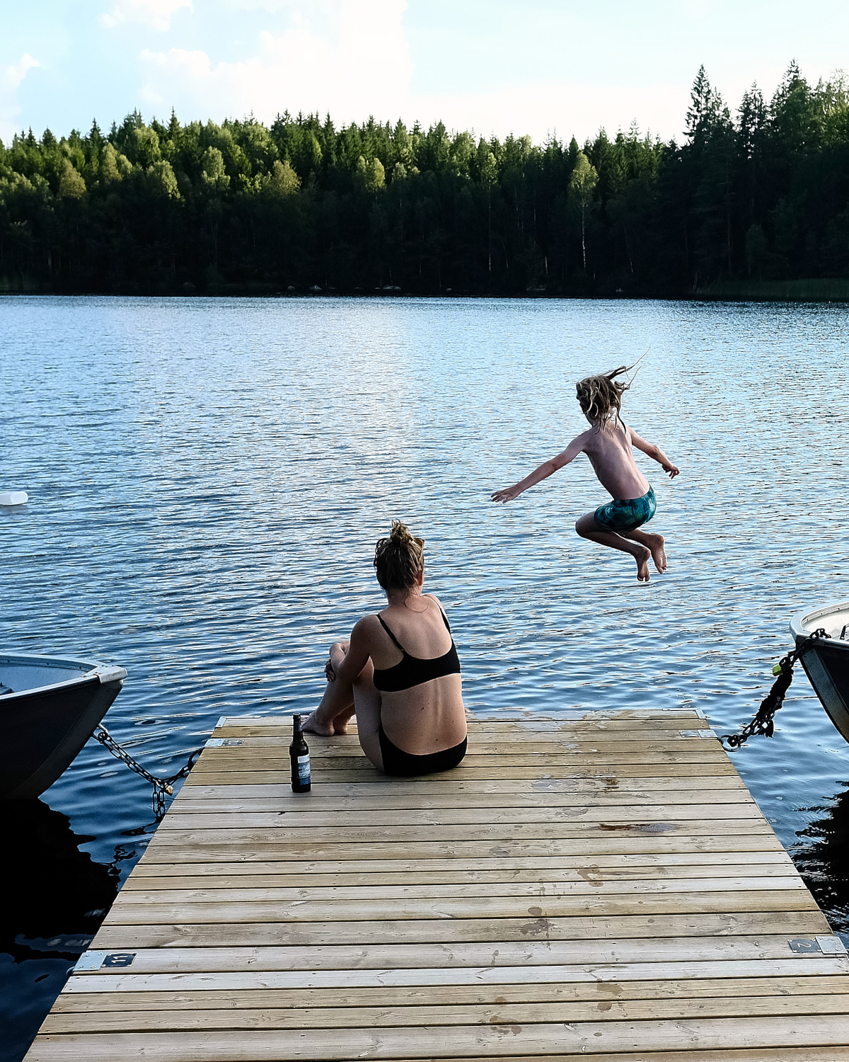 Kind springt vom Steg in den See